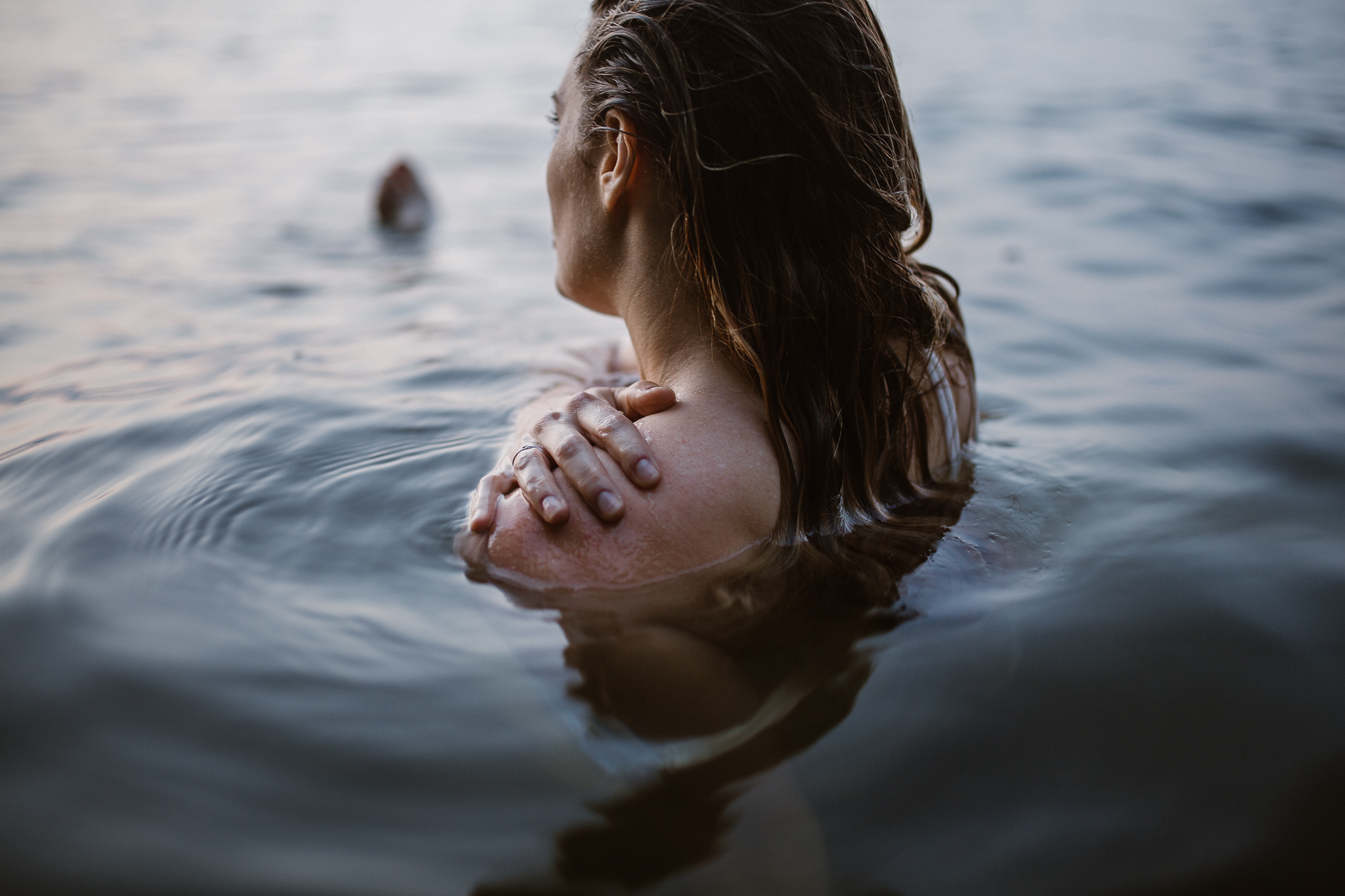 Captivating woman in an intimate lake session during a summer sunset.